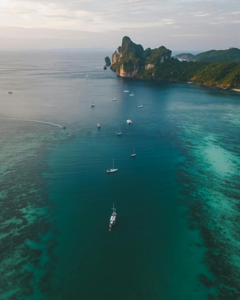 pexels-photo-1122408-1122408 Breathtaking aerial view of Ao Nang Bay in Thailand, showcasing serene waters and sailboats.