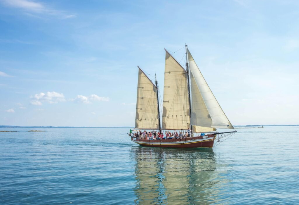 A picturesque sailboat with a competent crew enjoying a day at sea under clear skies.